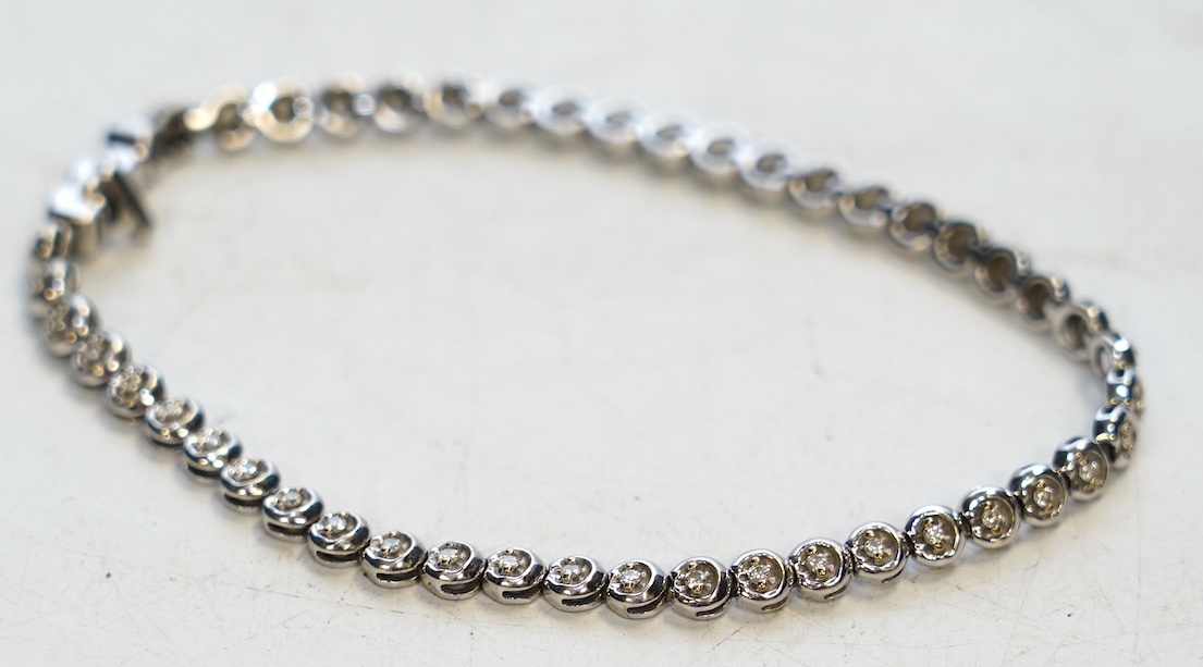 A modern 9ct white gold and diamond chip set line bracelet, 19.5cm, gross weight 8.9 grams. Condition - fair